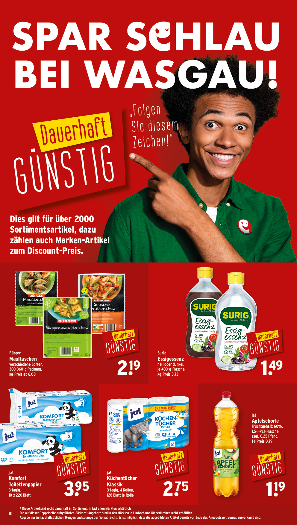 Ein lächelnder Mann in einem grünen Hemd zeigt auf ein gelbes Etikett mit der Aufschrift "dauerhaft günstig", unter dem sich preisreduzierte Lebensmittel befinden.