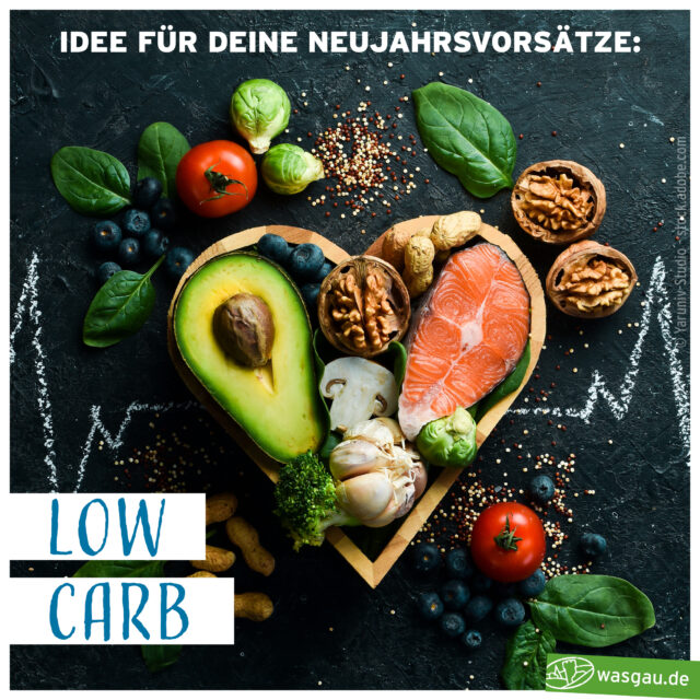 Ein herzförmiges Holztablett mit Lachs, Avocado, Nüssen und Eiern, umgeben von Spinat, Tomaten und anderem Gemüse, auf dunklem Hintergrund. Text: 